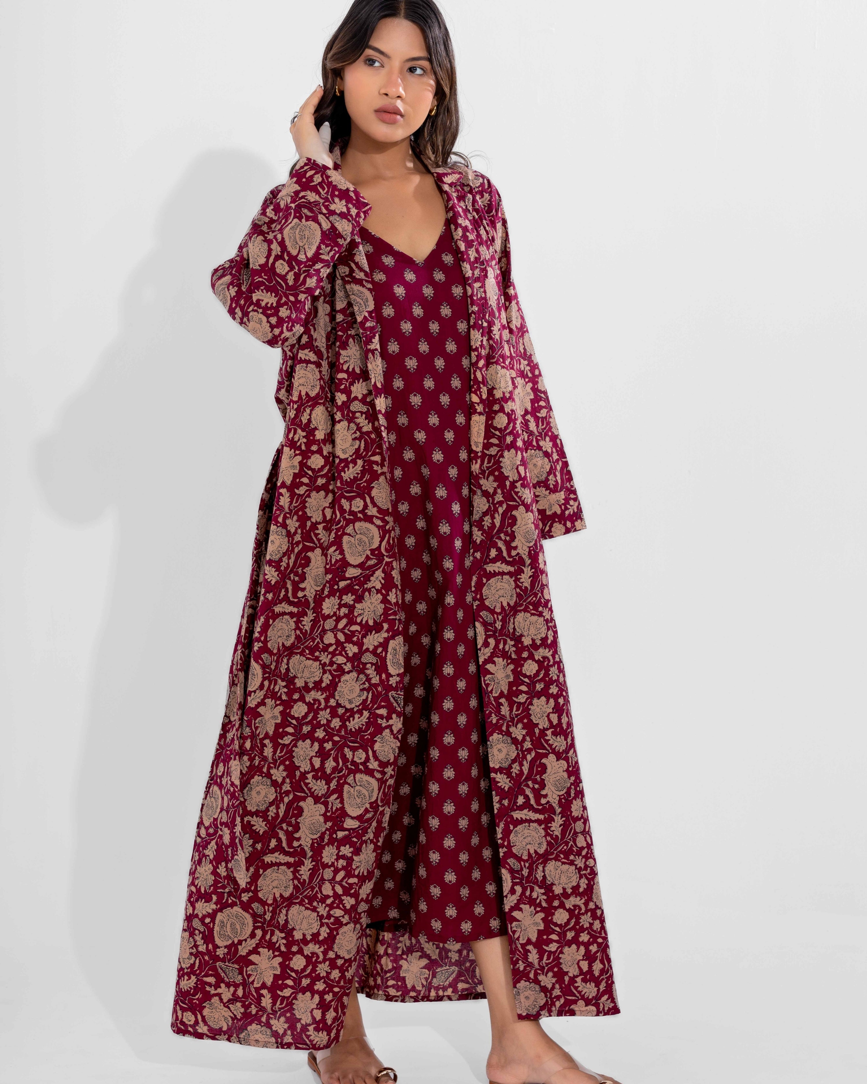 Woman wearing a vine moca floral dress with a matching long coat on a white background