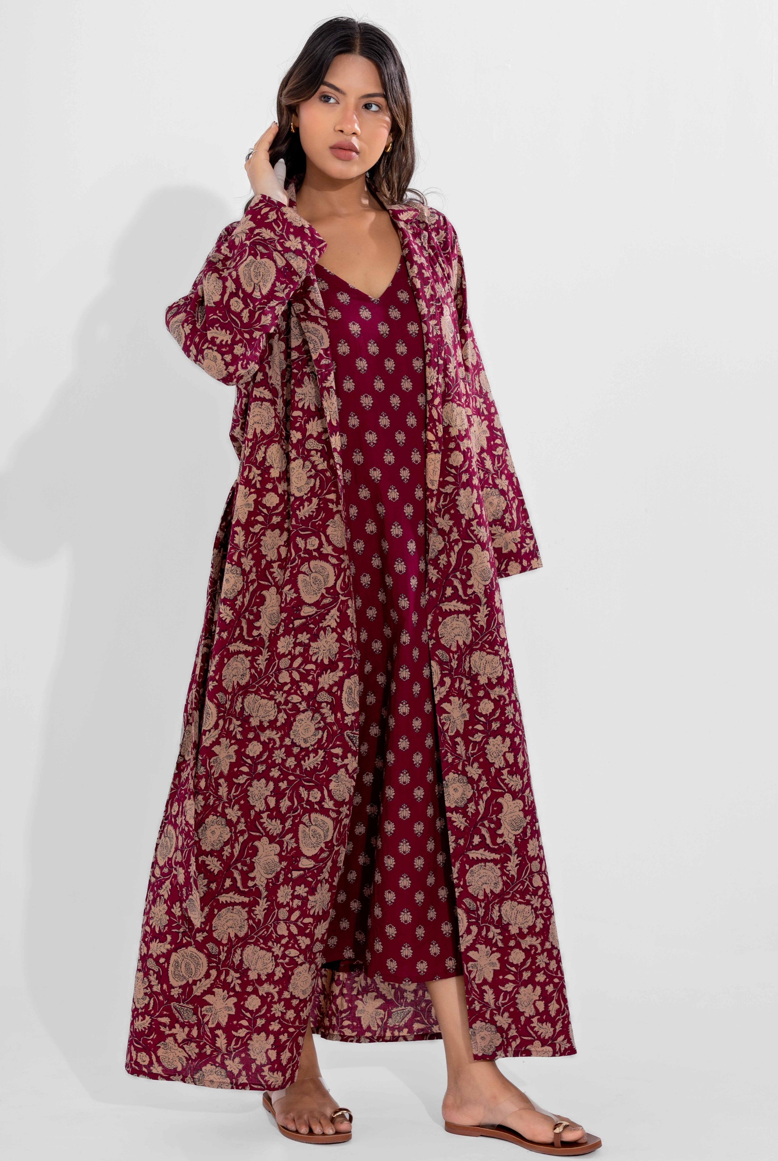 Woman wearing a vine moca floral dress with a matching long coat on a white background